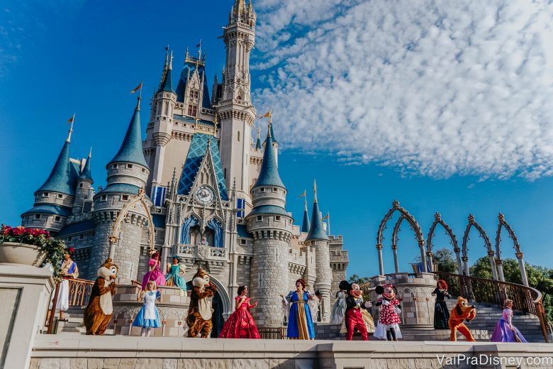 Foto do castelo da Cinderela no Magic Kingdom, com diversos personagens dançando em frente a ele 