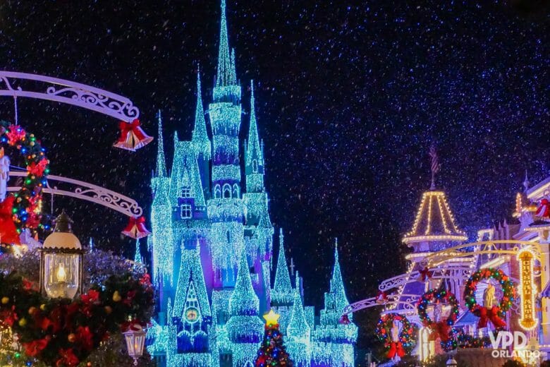 Imagem do castelo da Cinderella ao fundo, todo iluminado e com decorações de Natal na Main Street.