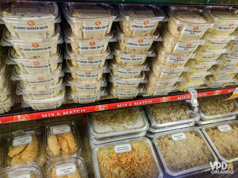 Prateleira do supermercado com várias embalagens plásticas com comida.