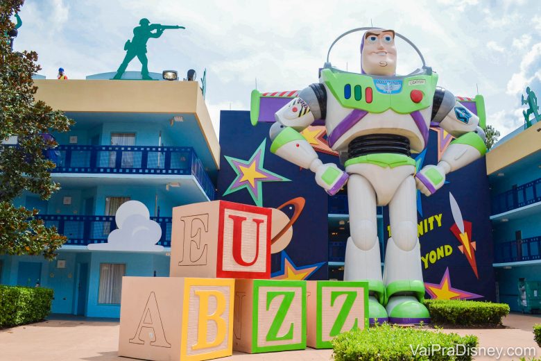 Foto do Buzz gigante na decoração da área do Toy Story do hotel All Star Movies, ao lado de brinquedos. 