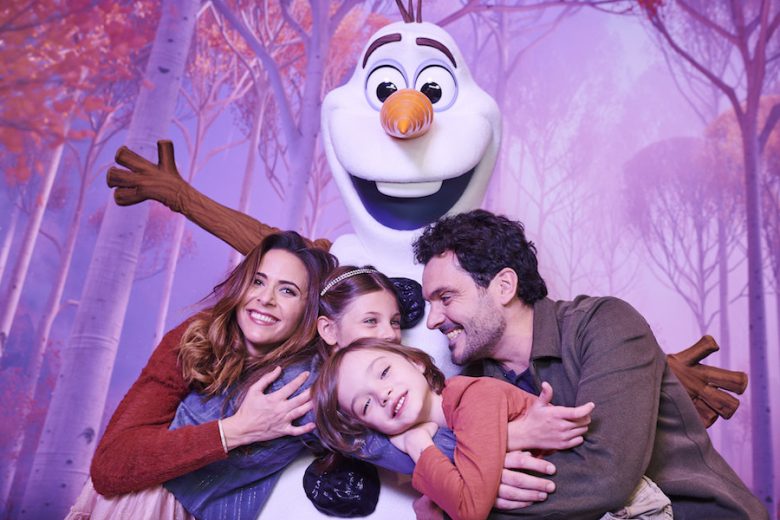 Encontro com o Olaf Foto de uma família abraçada ao Olaf durante o encontro com o personagem de Frozen