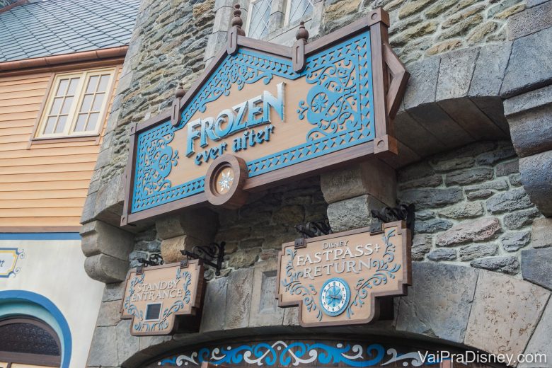 Foto da entrada da atração de Frozen no Epcot, Frozen Ever Efter. Há uma placa de madeira com o nome da atração e decorações em azul. 