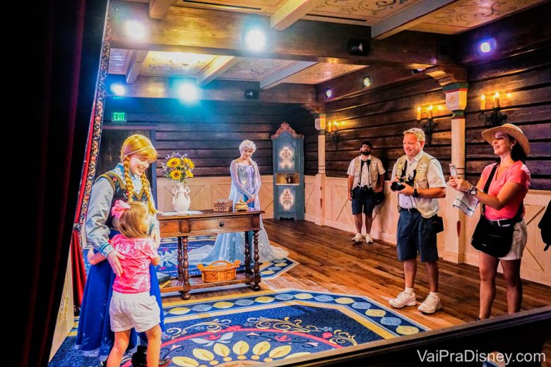 Encontro com a Anna e Elsa no Epcot, ainda com as roupinhas antigas. Foto de duas crianças abraçando a princesa Anna no cenário norueguês em que ela posa para fotos com visitantes no Epcot. 