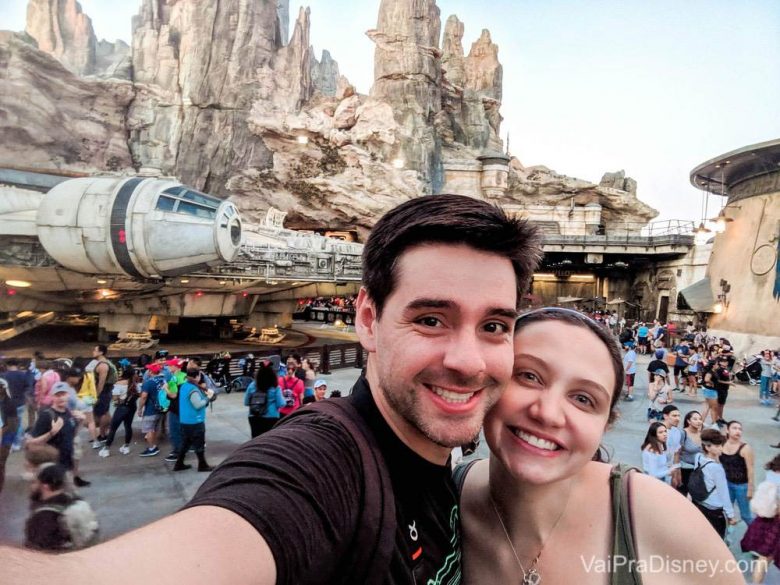 Foto da Renata e do Felipe sorrindo com a Millenium Falcon ao fundo na Star Wars Galaxy's Edge 