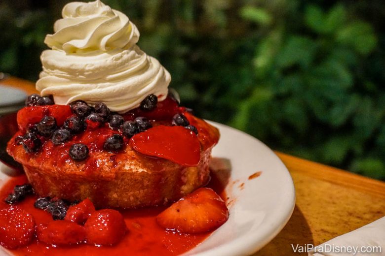 Foto da sobremesa do Garden Grill, um bolinho com calda de morango e chantilly em cima 