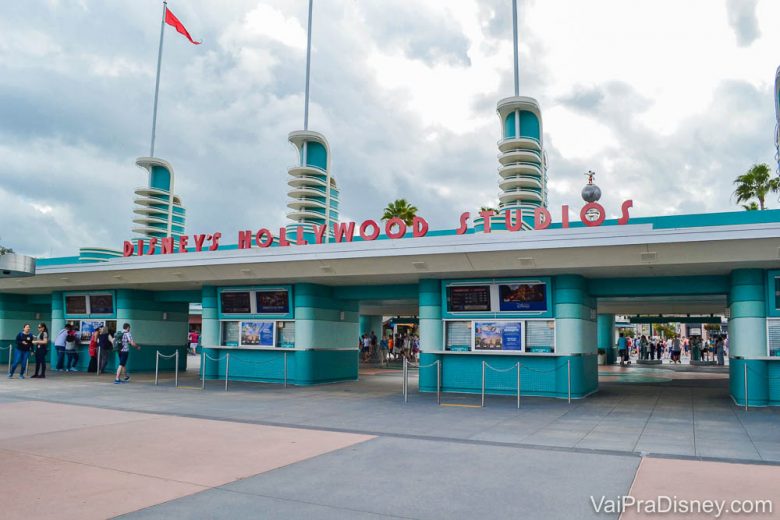 Foto da entrada do Hollywood Studios, que é pintada de azul com o nome do parque acima em vermelho. 