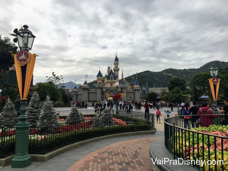 Foto da Disneyland de Hong Kong, com o castelo da Bela Adormecida ao fundo e o céu nublado. 