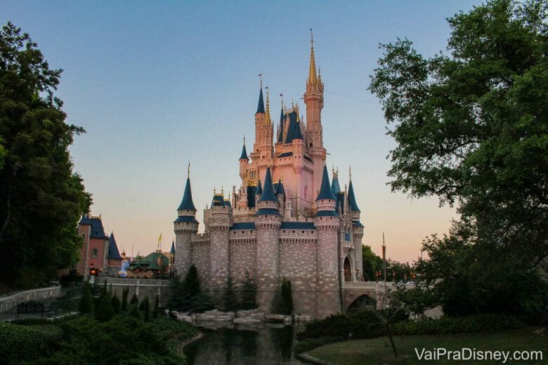 Foto do castelo da Cinderela no Magic Kingdom com o céu escurecendo atrás, em tons de azul e rosa 