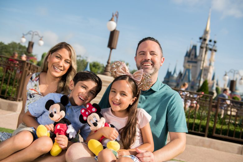 Foto de uma família com mãe, pai, filho e filha no Magic Kingdom, com o castelo da Cinderela ao fundo. 
