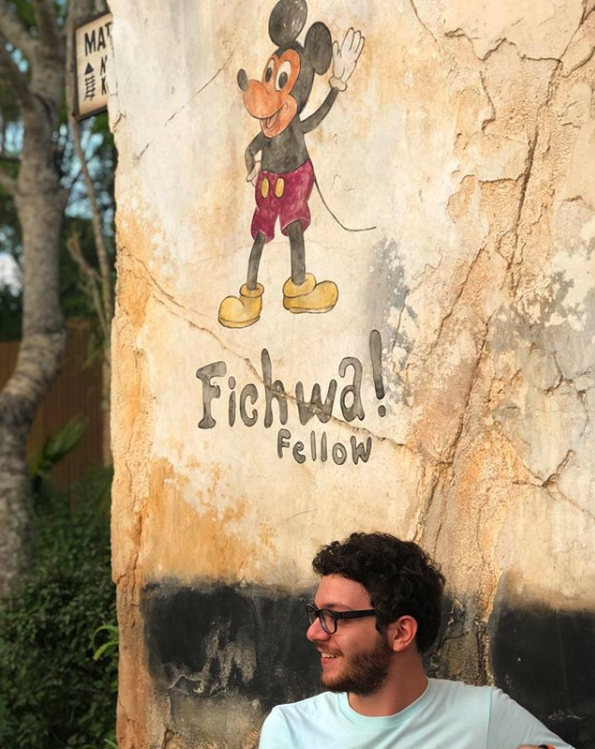 Foto do Marcelo, da equipe do VPD, em uma parede que tem o Mickey no Animal Kingdom 