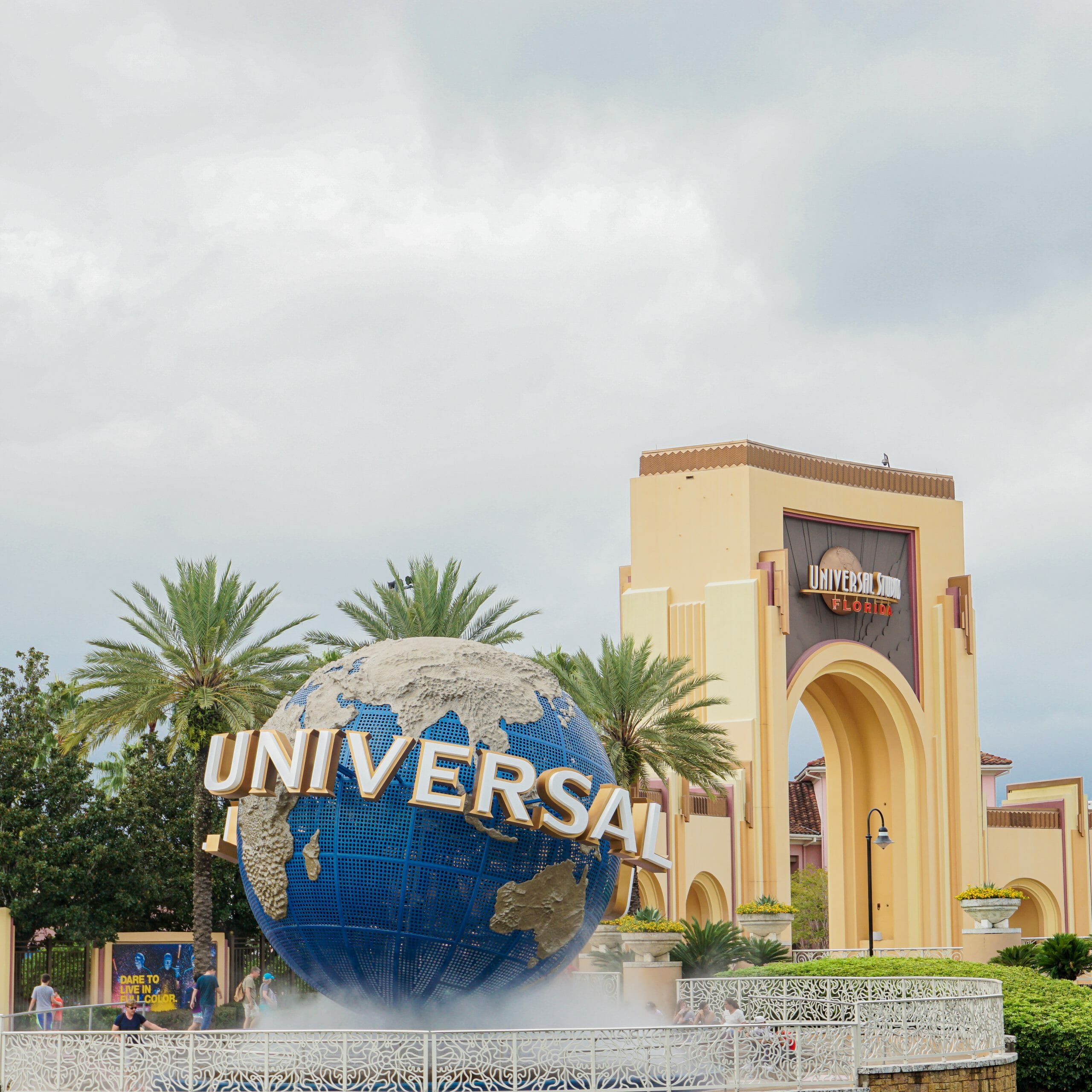 A imagem mostra a entrada do Universal Studios, que mostra o globo, símbolo da Universal, com o nome escrito em letras grandes ao seu redor.