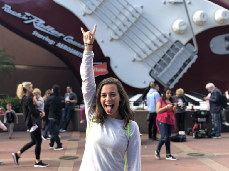 Foto de uma leitora do VPD em frente à Rock'n'Roller Coaster mostrando a língua 