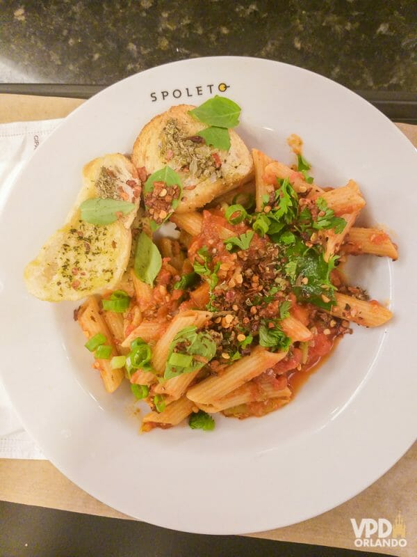 Foto da comida da Carol, que escreveu ao Viagem do Leitor, no Spoleto, um prato com macarrão, molho vermelho, pães com azeite e cebolinha