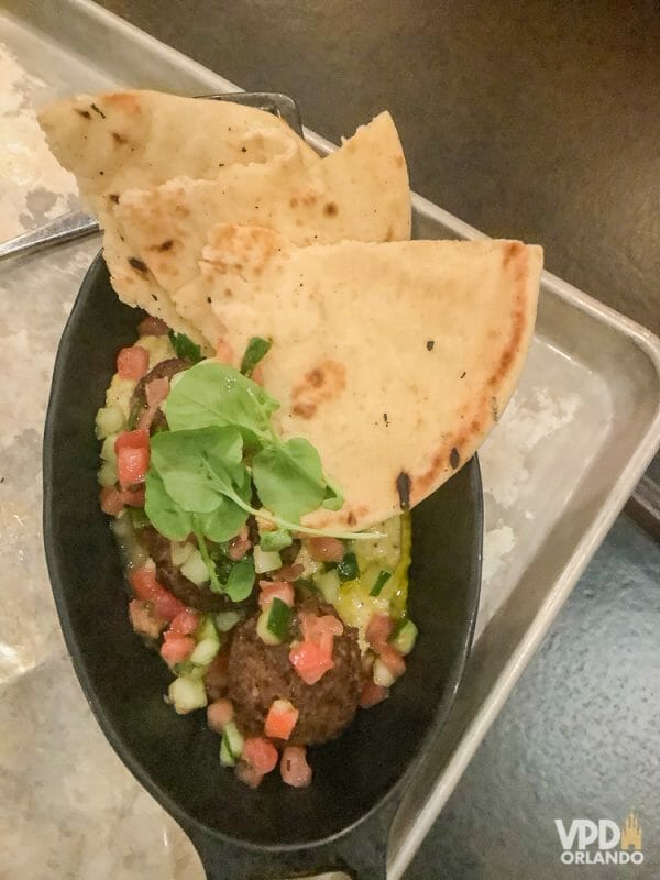 Foto da comida da Carol, que escreveu ao Viagem do Leitor sobre sua experiência como vegana na Disney, um prato com pão pita, hummus e kafta