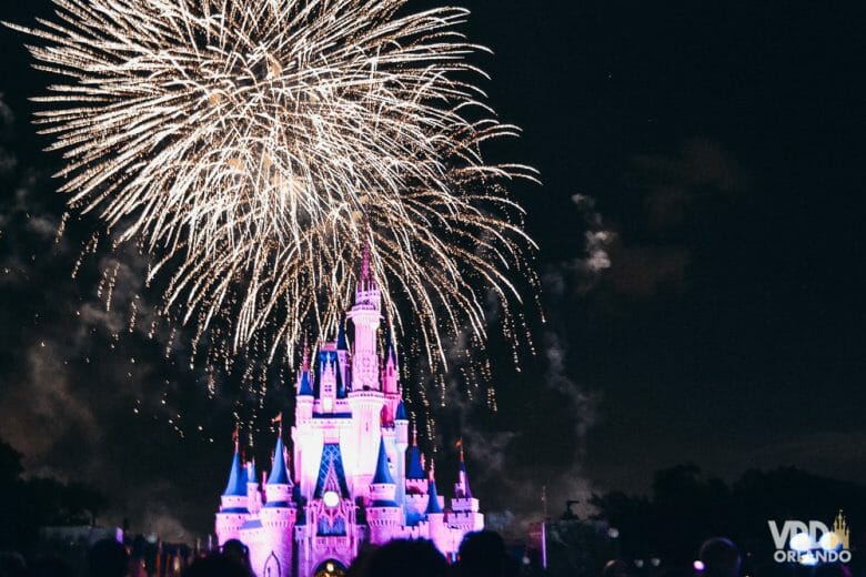 Foto do Wishes, o show de fogos, com o castelo da Cinderela iluminado em rosa. Todo mundo que viu sente saudades desse show! 