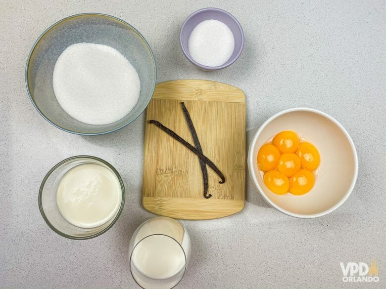 Foto dos ingredientes da receita: açúcar, ovos, fava de baunilha, leite e creme de leite fresco 