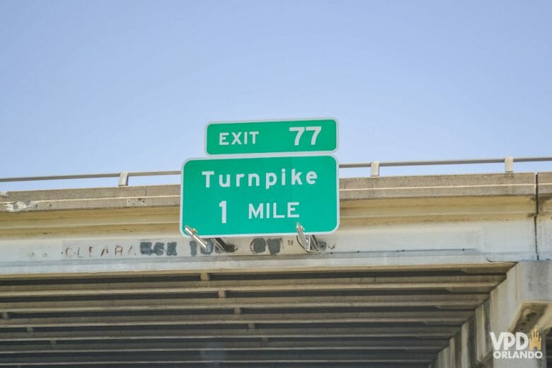 Se andar na Turnpike, principal estrada que liga Miami e Orlando, não vai ter como fugir dos pedágios de pagamento automático. Foto da placa da saída para a Turnpike (a placa diz "Exit 77/Turnpike 1 mile") 