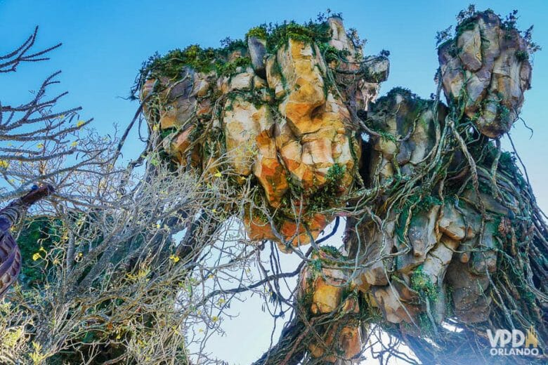 Pandora é incrível e uma das áreas mais legais dos parques, mesmo pra quem não curte o filme. Foto da decoração de Pandora, no Animal Kingdom, com as montanhas flutuantes cobertas de vegetação e o céu azul ao fundo 