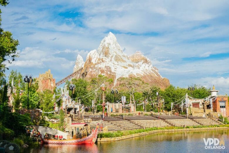 Foto da área da Ásia no Animal Kingdom, com a Everest ao fundo, o céu azul e parte do lago visível. 