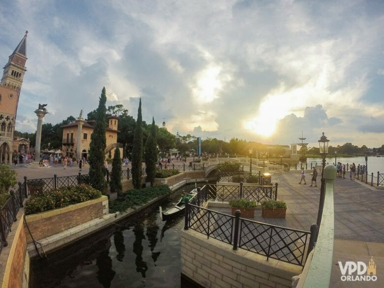 Pavilhão da Itália, com a representação dos canais de Veneza. Foto dos canais do pavilhão da Itália no Epcot, com as árvores ao redor e o céu meio nublado ao fundo. 