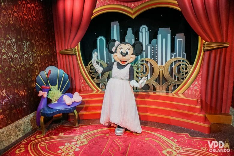 Foto da Minnie vestindo um vestido rosa em um cenário de Hollywood.