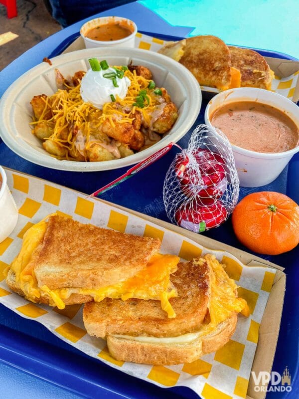 Esse pão com queijo e sopa de tomate é uma delícia. Foto do prato no Woody's Lunch Box do Hollywood Studios, que mostra um queijo quente com sopa de tomate e batatas com queijo. 