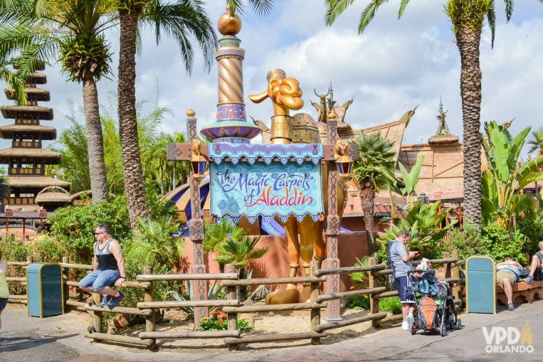 Foto da entrada da atração de Aladdin no Magic Kingdom. A placa é azul-clara e diz "The Magic Carpets of Aladdin" na mesma fonte usada para o filme. 