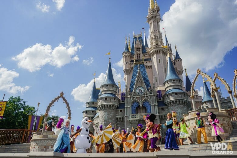 Magic Kingdom: o parque que todo mundo quer visitar e entra em quase todo pacote de viagem. Imagem do castelo da Cinderela com os personagens em frente (Mickey, Elsa, Olaf e outros) 