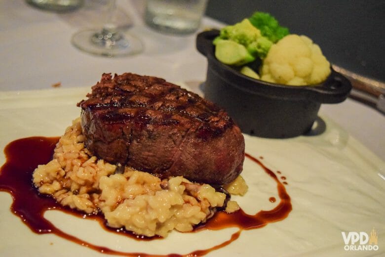 O Market to Table é um dos melhores restaurantes da região de Orlando. Foto do prato no Market to Table, com carne, risotto e legumes ao fundo. 