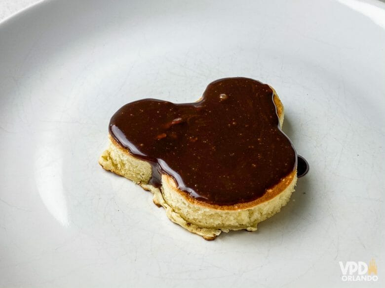 Pra fazer essa versão do Mickey, é só usar um cortador de biscoito ;) Foto de um prato com uma panqueca em formato de Mickey, coberta de chocolate 