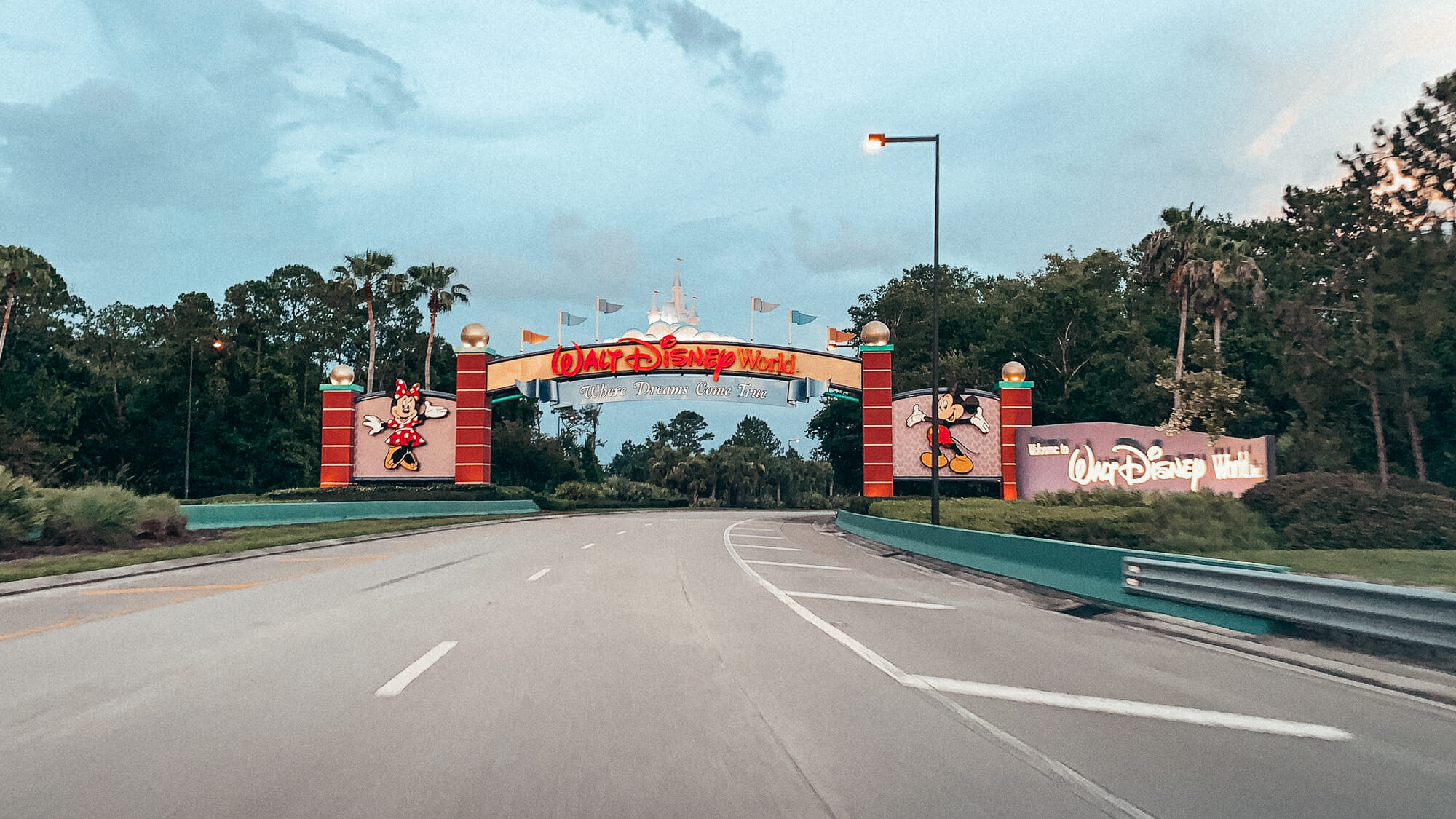 Foto da entrada do complexo Disney em Orlando. Há um arco decorado com o Mickey e a Minnie de cada lado e as palavras "Walt Disney World" acima