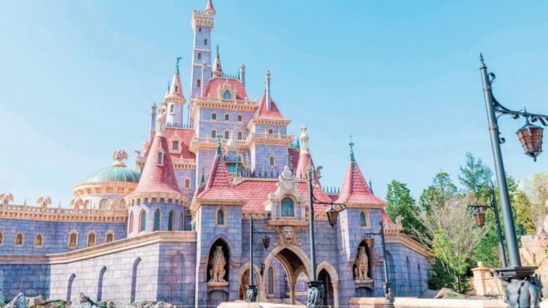 Foto do castelo da Fera, que está presente na nova área da Bela e a Fera em Tóquio. Imagem da nova área temática da Bela e a Fera na Disneyland de Tóquio, mostrando o castelo da Fera, pintado de lilás e com telhas cor-de-rosa.