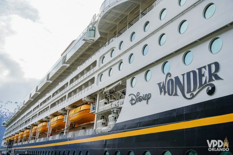 Navio da Disney Cruise Line parado no porto. O texto na lateral mostra que esse é o navio Disney Wonder.
