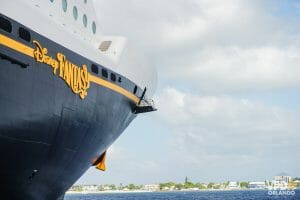 Foto do navio de cruzeiro da Disney Cruise Line em alto mar, com o letreiro em amarelo na lateral indicando que é o Disney Fantasy
