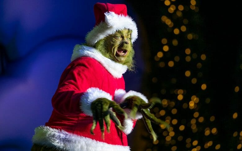 Foto do personagem Grinch vestido de Papai Noel.