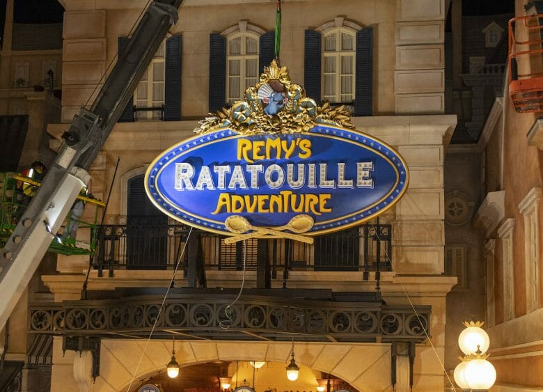 Fachada da Remy's Ratatouille Adventure , no Epcot, com uma placa azul, amarela e dourada 