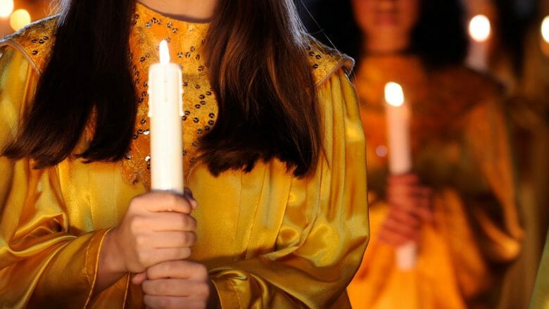 Cada um dos participantes do coral carrega uma vela simbólica Detalhe da vela elétrica carregada por cada integrante do coral Candlelight Processional