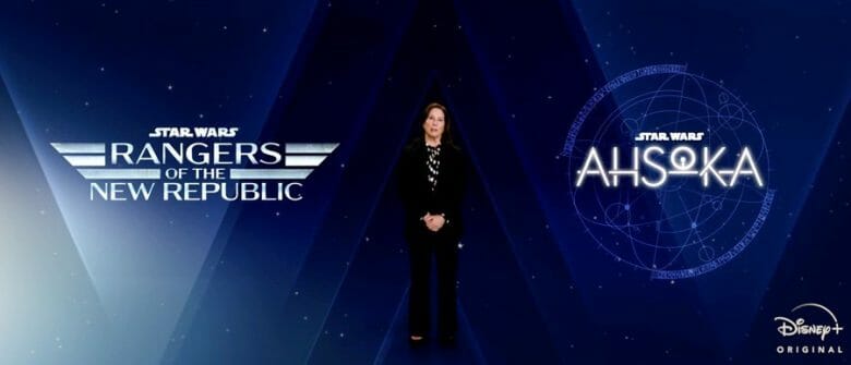 A imagem mostra uma mulher, Kathleen Kennedy, anunciando as séries Rangers of the New Republic e Ahsoka que vão chegar ao Disney Plus. Ela está em frente a uma tela azul com os nomes das séries.