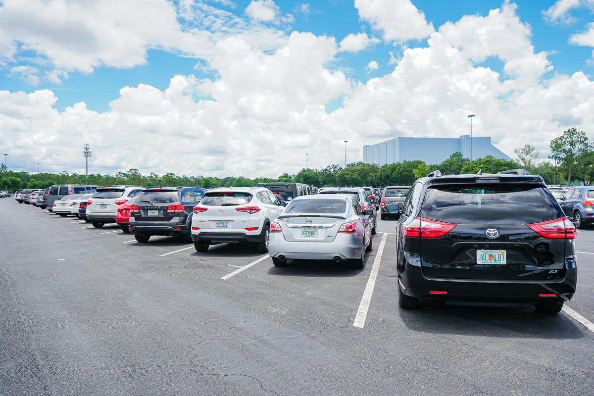 Imagem de um estacionamento, com vários carros parados nas vagas.