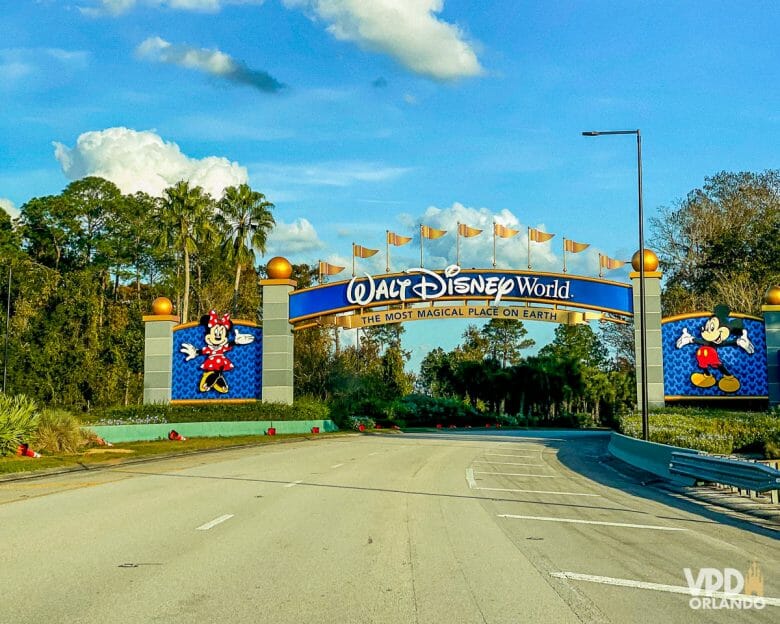 Imagem do portal de entrada da Disney, que foi reformado para o aniversário de 50 anos. Ele é azul escuro, cinza e tem detalhes em dourado. O Mickey está do lado direito e a Minnie do lado esquerdo.