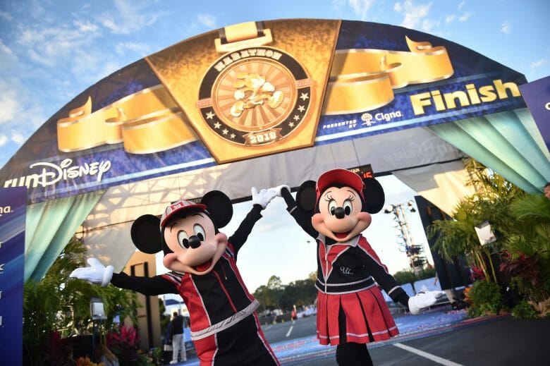 Mickey e Minnie com roupas de corrida em frente à chegada da corrida da Disney na maratona de 2019 