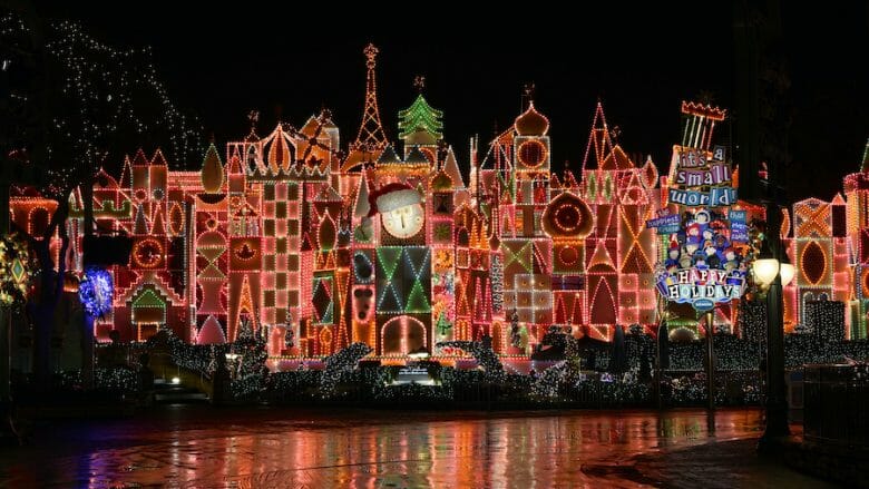 Essa iluminação temática no It's A Small World fica bem linda, né? Fachada do It's A Small World com luzes natalinas em vermelho com detalhes em laranja e verde.