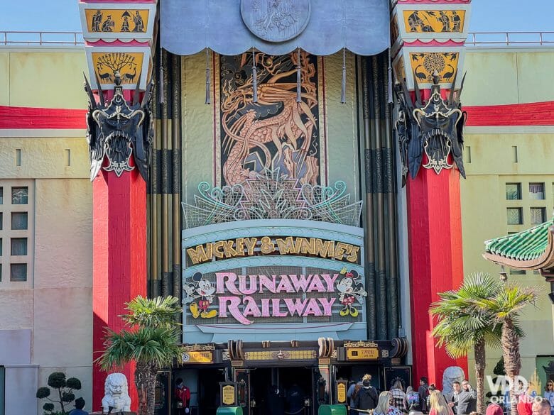Foto da fachada da Mickey & Minnie's Runaway Railway, com o letreiro em neon e ilustrações dos personagens. Essa atração está temporariamente no Genie+ no Hollywood Studios