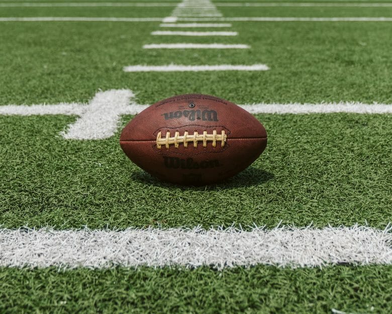 Uma bola de futebol americano no campo. O Super Bowl é a final do campeonato de futebol americano da NFL.
