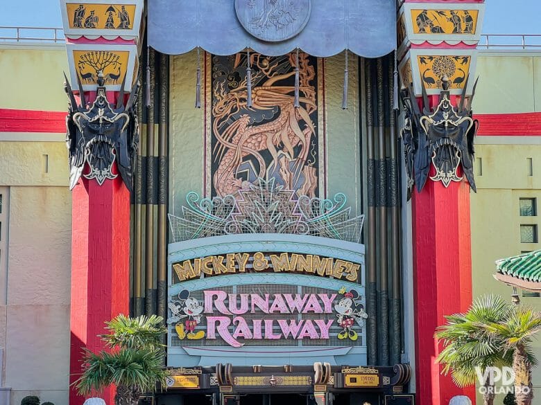 Foto da entrada da Mickey & Minnie's Runaway Railway, que mostra os dois personagens e o título em um letreiro neon cor-de-rosa 