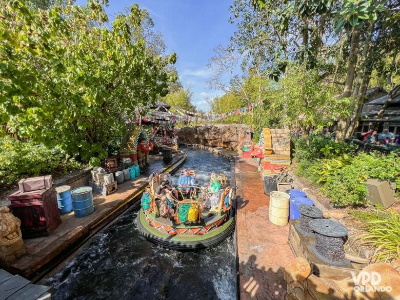 Imagem do barco no Kali River Rapids, com várias decorações e adereços nas margens.