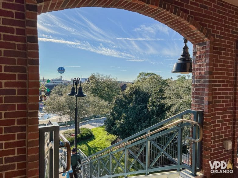 Foto da vista do Disney Springs durante o dia. Dá pra ver o balão ao fundo, e há um arco de tijolos em frente.