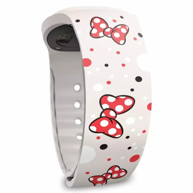 Foto de uma das MagicBand+, branca e com bolinhas pretas, brancas e vermelhas e laços vermelhos da Minnie.