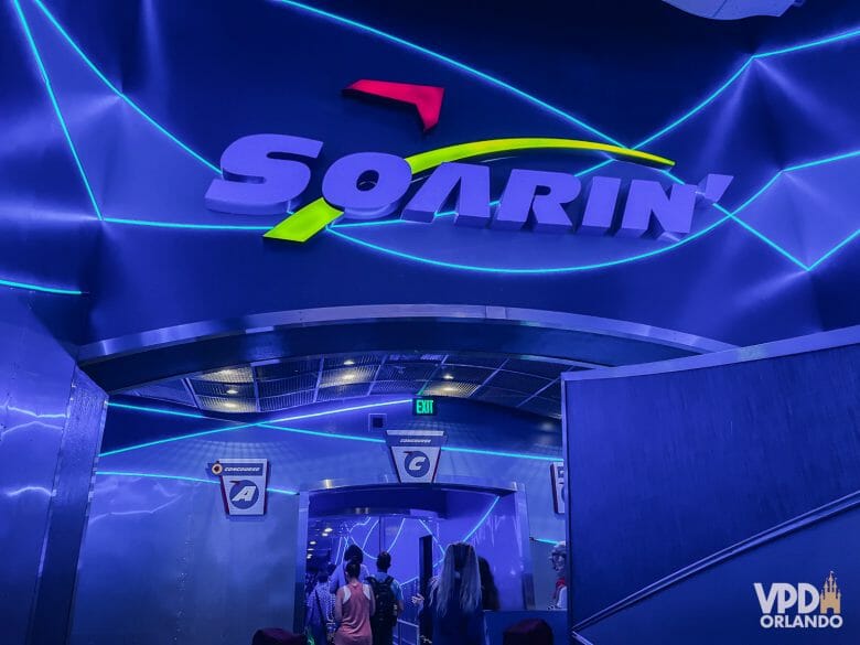 Foto da fila do Soarin'. O ambiente está iluminado em azul e há pessoas na fila.