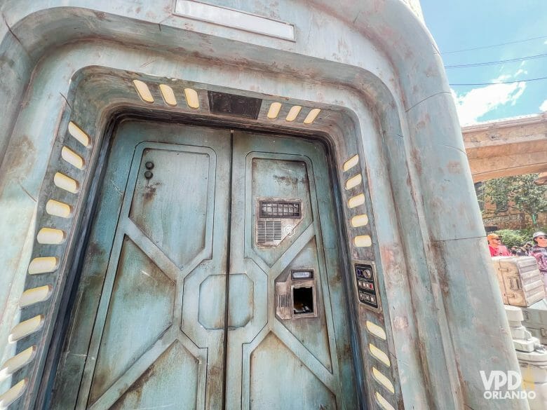 foto de uma porta onde é possível escanear a magicband+ e receber créditos no jogo batuu bounty hunters. ela é pesada e de ferro, com aparência de desgaste.